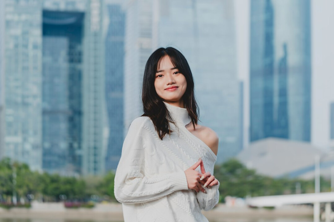 Studio portrait of a Chinese Singaporean woman in her 30s wearing business casual attire