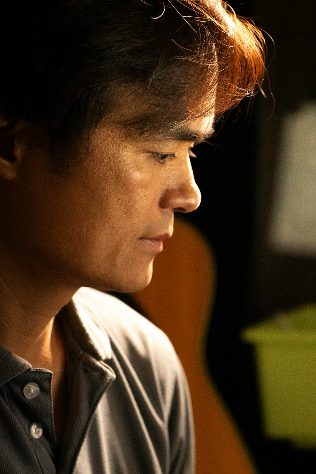 Studio portrait of a Chinese Singaporean man in his 30s wearing a casual shirt